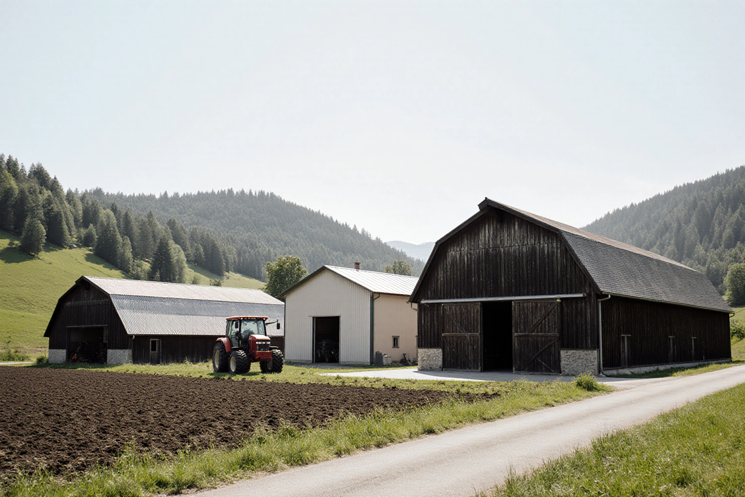 Landwirtschaftliche Wirtschaftsgebäude mit bearbeiteter Fläche und angrenzendem Wald
